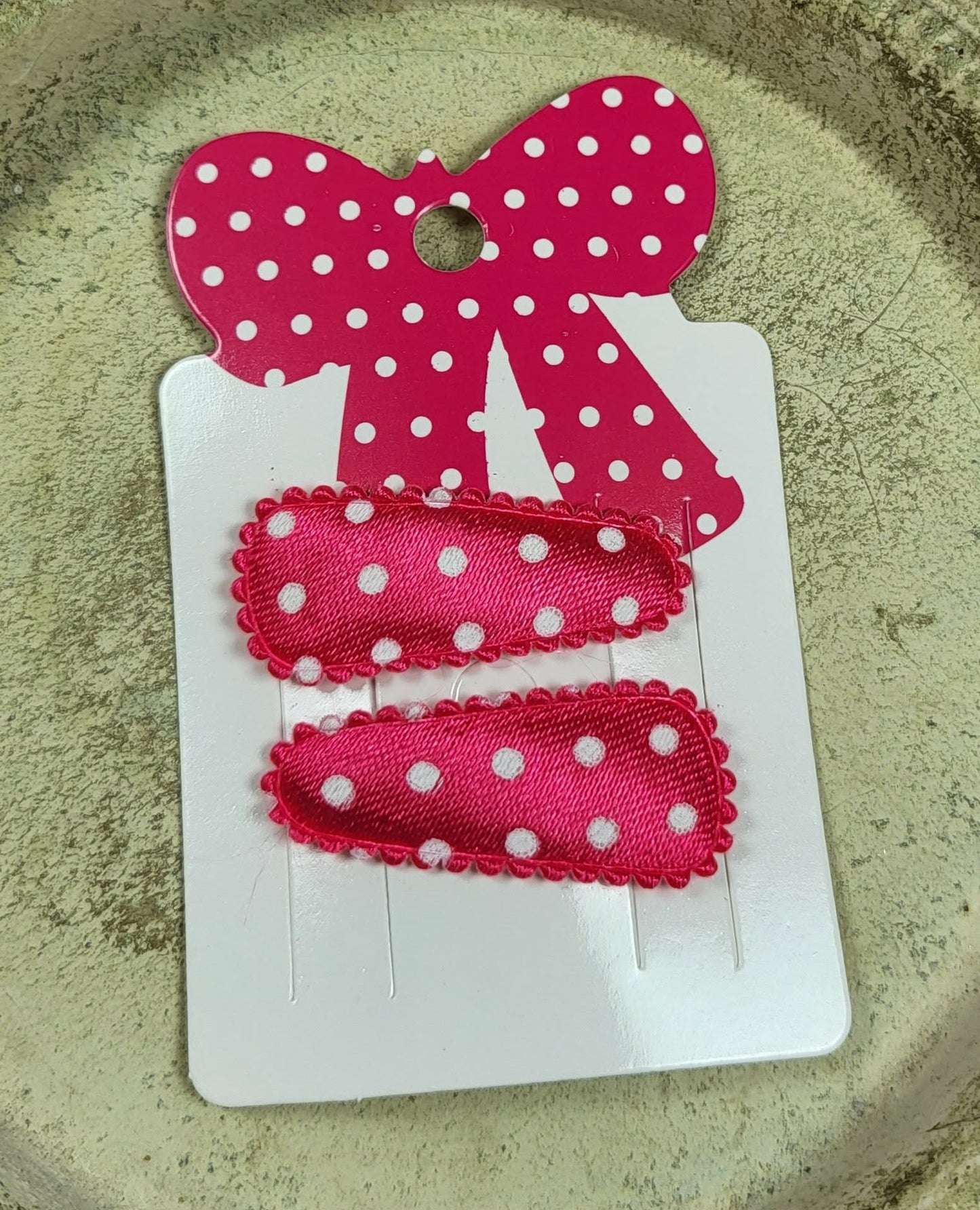 Baby klikspeld satijn donkerroze met witte stippen