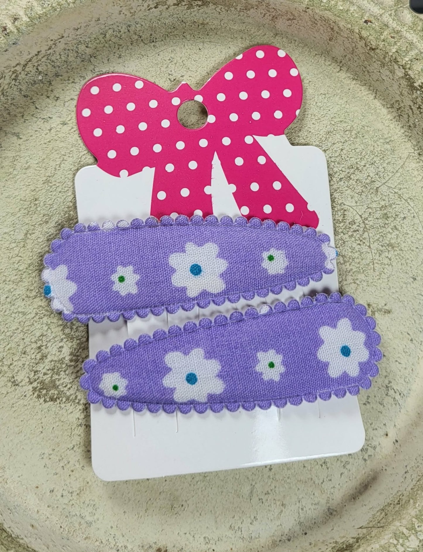 Kind klikspeld paars met witte bloemen en gekleurde stippen